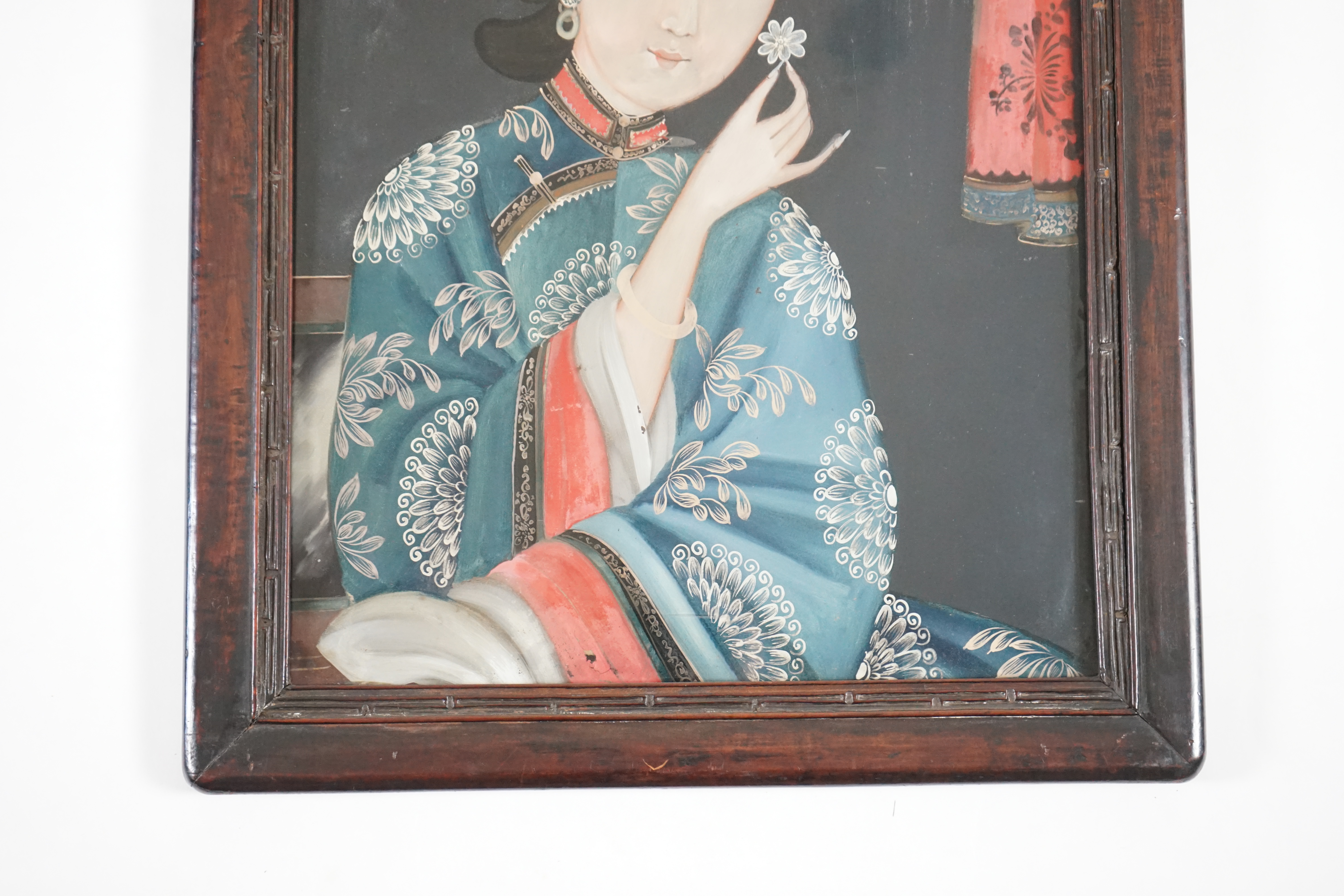 A Chinese reverse painting on glass of a lady holding a flower, 19th century